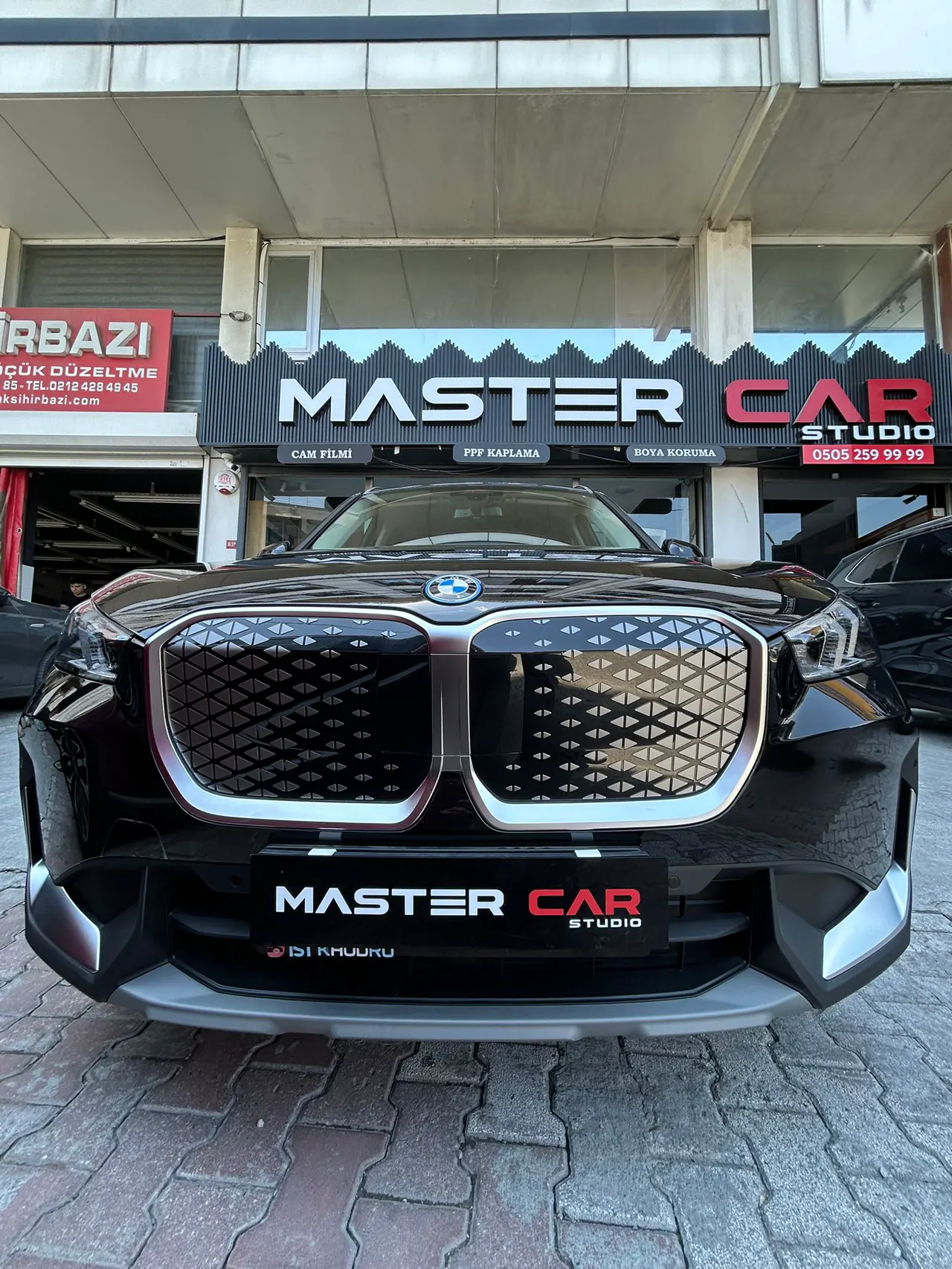 Master Car Studio tabelası önünde PPF kaplamalı BMW